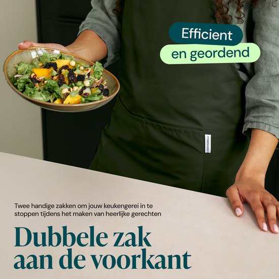 Femme portant un tablier de cuisine tient une salade. Le tablier vert a des doubles poches avant.
