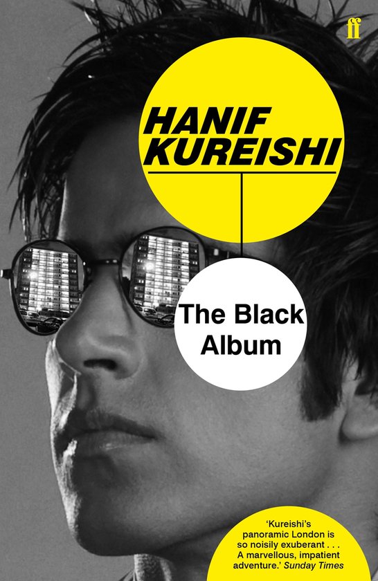 Boek "The Black Album" met Hanif Kureishi op de kaft, met reflecties van gebouwen in zijn bril.