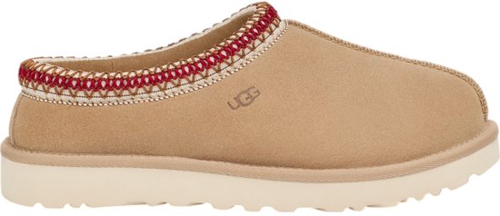 Bruine suède UGG slipper met gevlochten rode en witte bies en een cleane off-white zool.