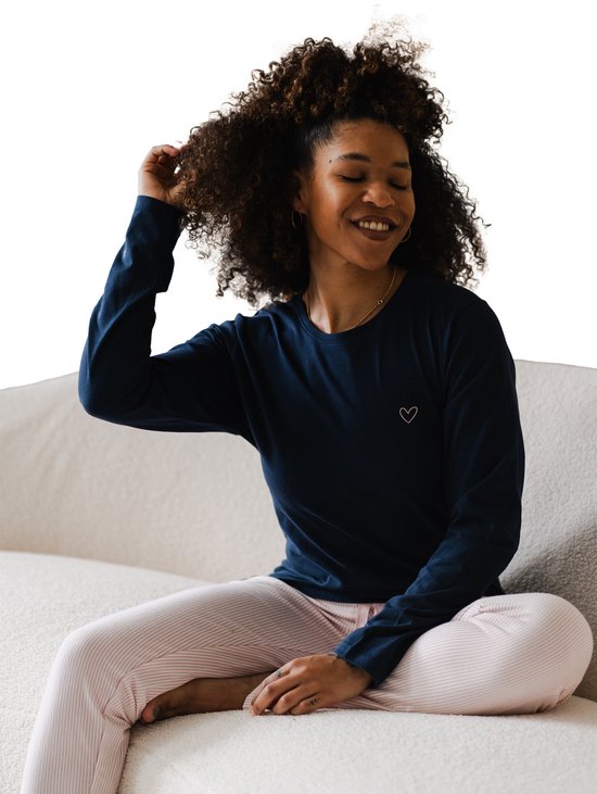 Donkerblauwe longsleeve met een klein roze hartje op de borst, gedragen door een model met krullend haar.
