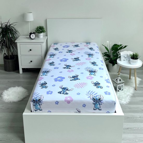 Wit hoeslaken met een print van Stitch uit Lilo & Stitch, omringd door paarse en roze bloemen en bladeren.