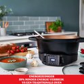 Zwarte Russell Hobbs multicooker op een aanrecht, naast een kom soep en brood. Energiezuiniger dan een traditionele oven.