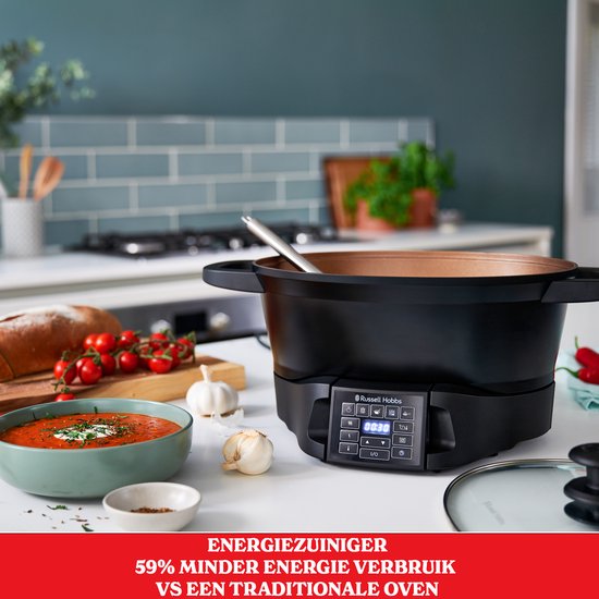 Zwarte Russell Hobbs multicooker op een aanrecht, naast een kom soep en brood. Energiezuiniger dan een traditionele oven.