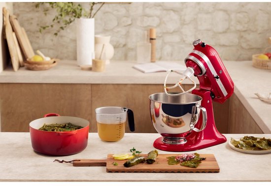 Rode KitchenAid Artisan keukenmachine in een keuken met een pan, graan, en hapjes.