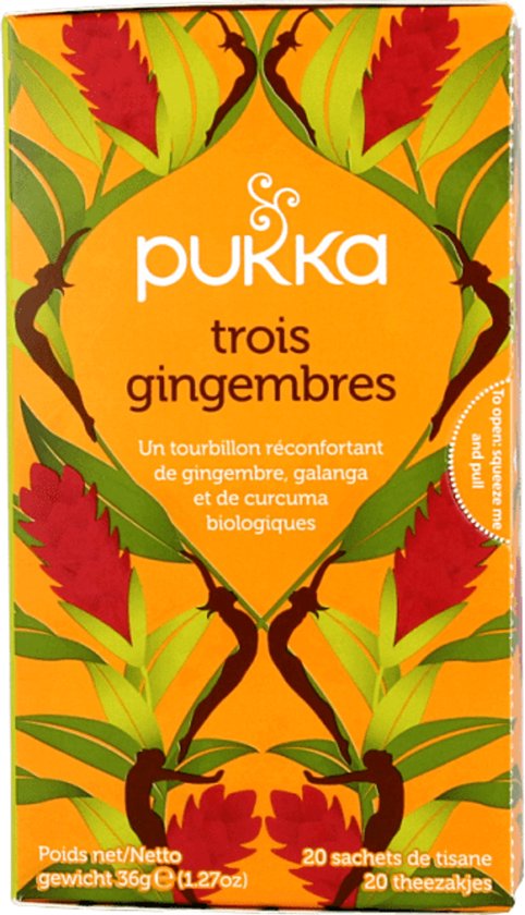 Pukka trois gingembres biologische thee verpakking met rode gemberbloemen en groene bladeren, op een witte achtergrond.