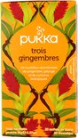 Pukka trois gingembres biologische thee verpakking met rode gemberbloemen en groene bladeren, op een witte achtergrond.