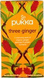Pukka three ginger thee verpakking met oranje achtergrond en afbeeldingen van gemberbloemen en bladeren.