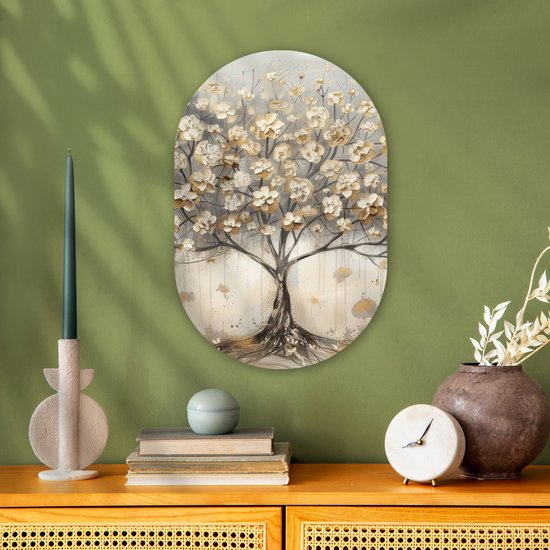 Ovaal kunstwerk met een beige, gouden en grijze boom, opgehangen boven boeken en decoraties op een groene muur.