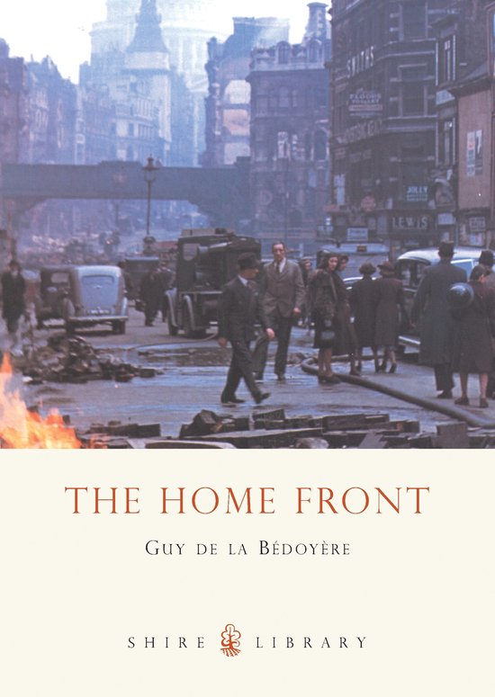 Boekomslag: 'THE HOME FRONT' door Guy de la Bédoyère, met een afbeelding van een drukke straat met puin en vuur.