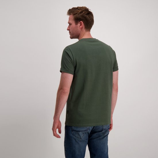 Man met rug naar de camera, draagt donkergroen Cars Jeans T-shirt met korte, omgeslagen mouwen en spijkerbroek.