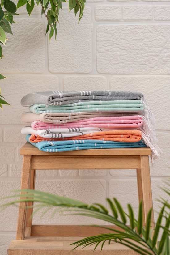Stapel handdoeken in verschillende kleuren: grijs, mintgroen, beige, roze, oranje en blauw, met strepen en franjes.