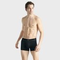 Man in een strakke zwarte Adidas boxer, toon op borst en buik.
