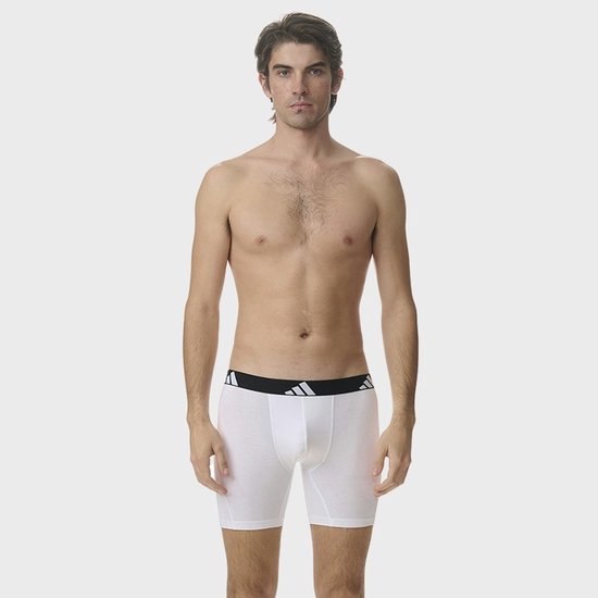 Man in witte Adidas boxer met zwarte tailleband met logo.