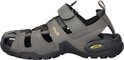 Grijsbruine Teva sandalen met klittenbandsluiting, gele veters en "Teva" logo.