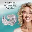Zilverkleurige verstelbare ring met gedraaide cirkelmotieven, gedragen op een lachend model.