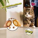 Een kat kijkt nieuwsgierig naar twee doorsneden van Catisfactions Kip & Eend snacks met tekst 'Onweerstaanbaar voor katten'.