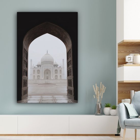 Une peinture du Taj Mahal à travers une arche, accrochée dans un salon moderne.
