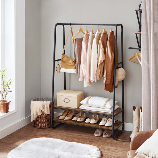 Zwart kledingrek met 2 houten planken, gevuld met kleding, schoenen, tas, mand en een box.