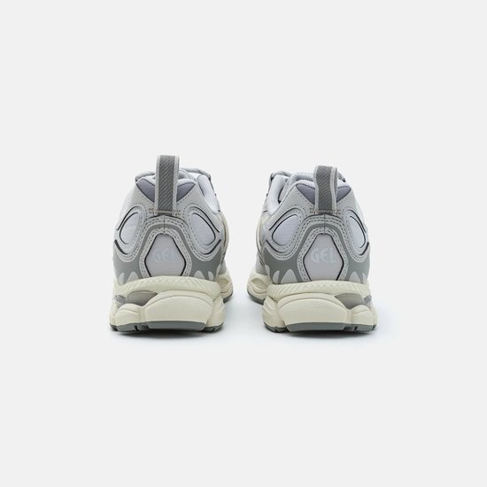 Achterkant van grijze ASICS sneakers met beige zolen en 'GEL' logo op de hiel.