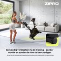 Vrouw met sportkleding op een zwarte hometrainer met gouden accenten, in een woonkamer.