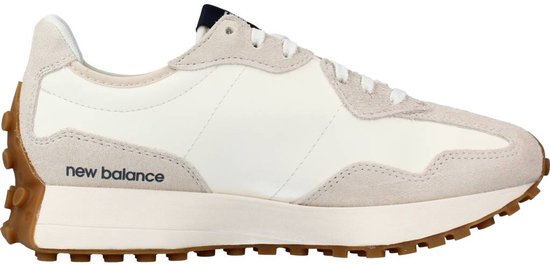 Zijaanzicht van een witte sneaker met beige suède en 'new balance' op de zool.