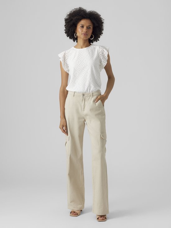 Femme portant un haut blanc court à volants et détails ajourés, et un pantalon cargo beige.