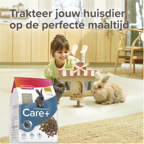 Meisje kijkt lachend naar twee konijnen bij een kartonnen huisje met zak konijnenvoer.