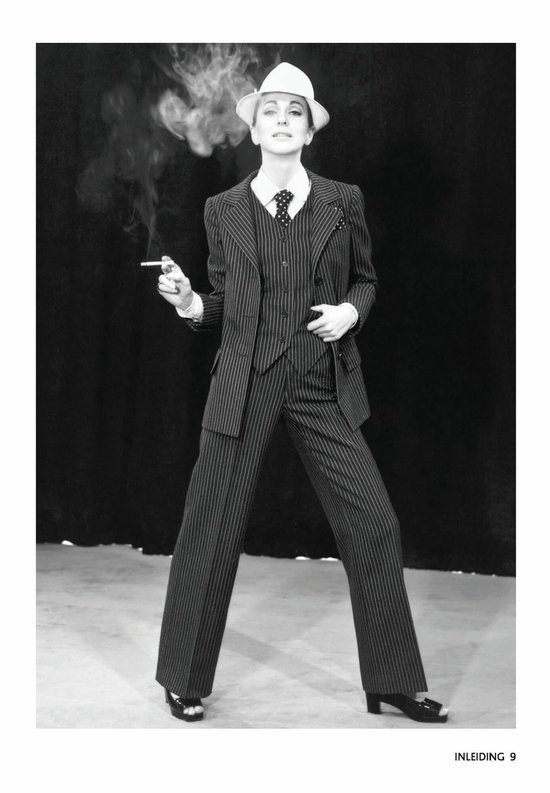 Model in krijtstreep pinstripe pak, met vest en gestreepte das, witte hoed, rookt een sigaret.