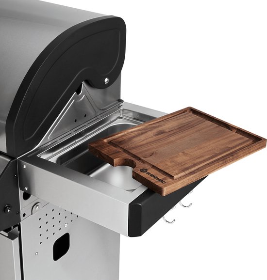 Houten snijplank op uitklapbare zijtafel van roestvrijstalen barbecue.