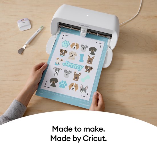 Cricut Joy Xtra snijmachine met een vel bedrukt met hondenpootjes en hondenkopjes.