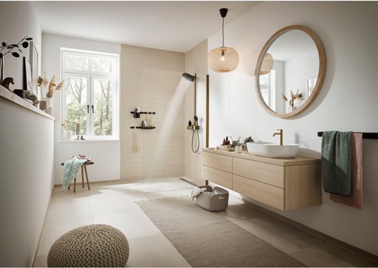 Ruime badkamer met houten wastafelmeubel, douche, planten en gouden kraan.