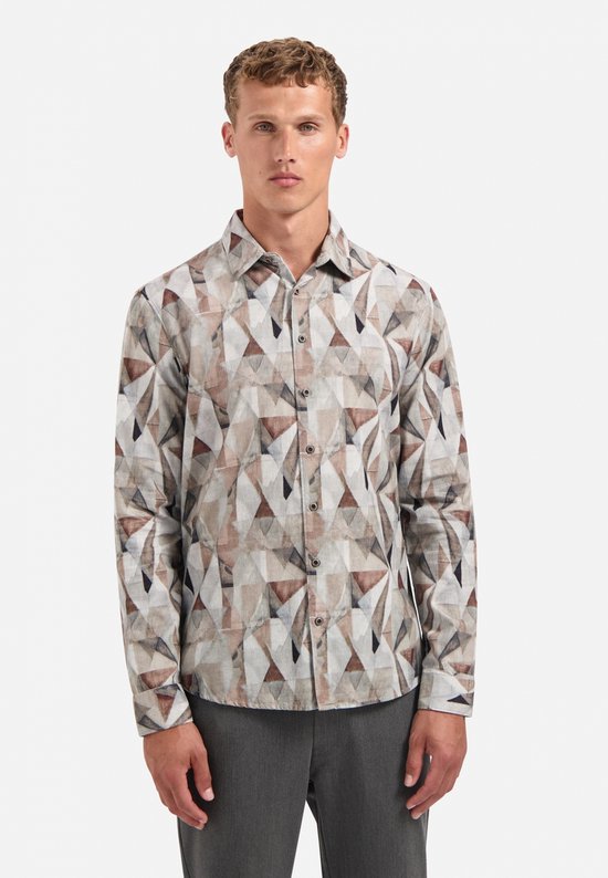 Model draagt een overhemd met all-over geometrische print in bruin-, grijs- en wittinten op corduroy.