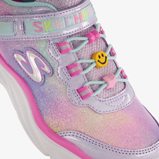 Close-up van roze en pastelkleurige Skechers sneaker met glitter, regenboogprint, klittenbandsluiting en smiley veterbedel.