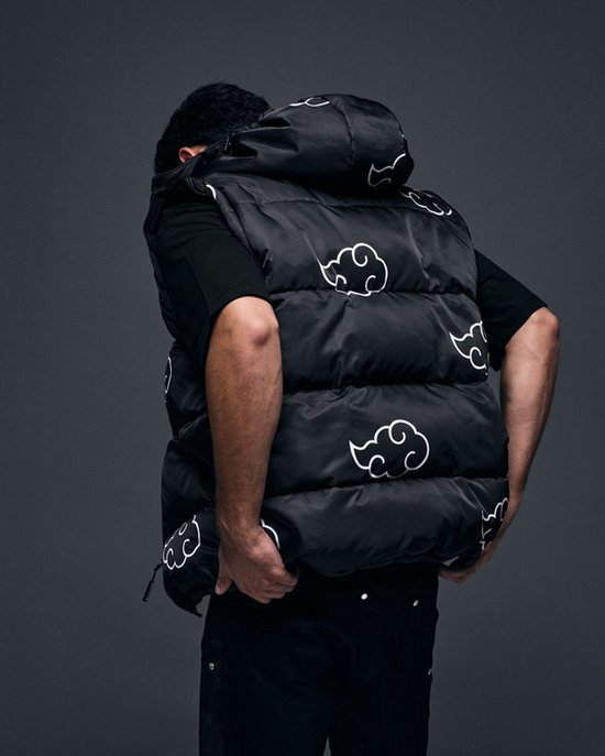 Model in zwarte puffer bodywarmer met witte wolkenprint, van achteren gezien.