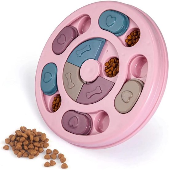 Boîte de puzzle alimentaire interactive rose pour chiens et chats, remplie de croquettes, avec un tas de croquettes à côté.