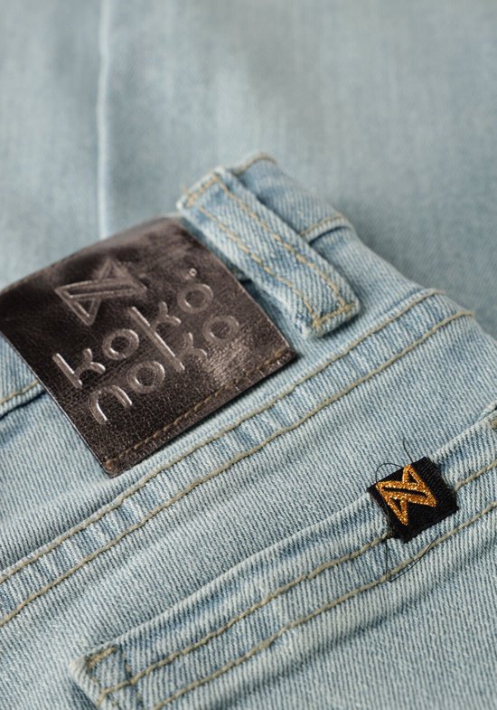 Detailopname van het Koko Noko label op een lichtblauwe spijkerbroek.