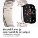 Zilverkleurig metalen bandje met kliksluiting, bevestigd aan een smartwatch.