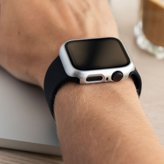 Zilveren smartwatch case met zwarte band, gedragen op een arm.