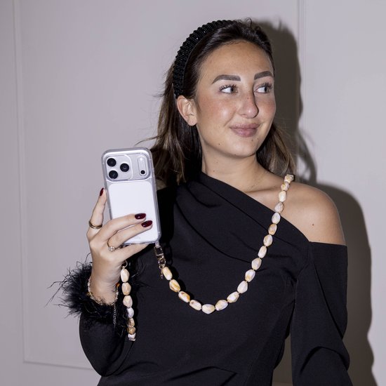 Model met hoofdband en zwarte jurk, houdt transparant iPhone 11 Pro hoesje met beige en wit kralensnoer vast.