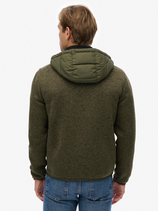 Achterkant van een groene jas met gewatteerde capuchon, gebreide mouwen en body. Gedragen door een man met spijkerbroek.