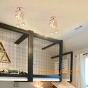 Twee halve maan kroonluchters met sterren aan het plafond van een slaapkamer met een hoogslaper.