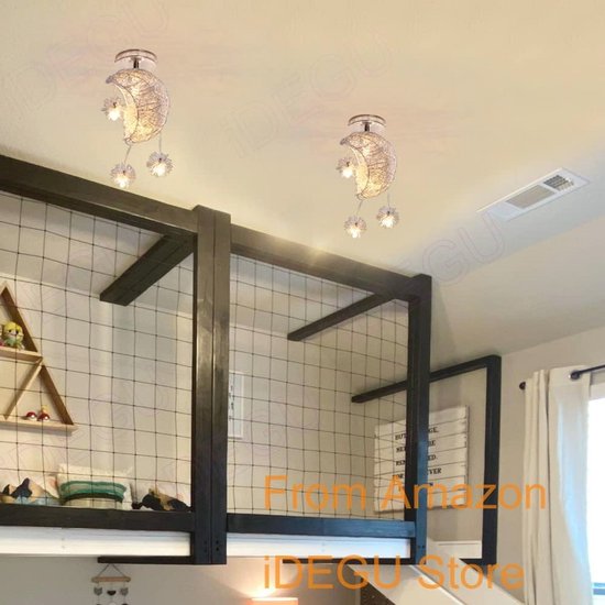 Twee halve maan kroonluchters met sterren aan het plafond van een slaapkamer met een hoogslaper.
