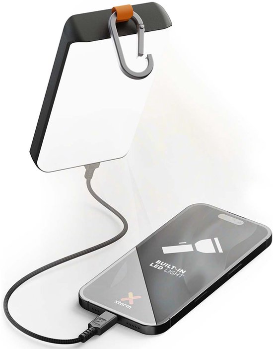Zwarte Xtorm powerbank met zonnepaneel en karabijnhaak, die een smartphone oplaadt met de ingebouwde LED-lamp.