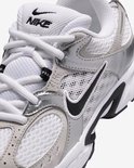 Close-up van de voorkant van een witte Nike sneaker met zilveren details en zwarte swoosh.