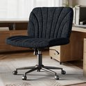 Zwarte, gestreepte bureaustoel met een golvend rug- en zitvlak, staand op een vloerkleed naast een bureau.