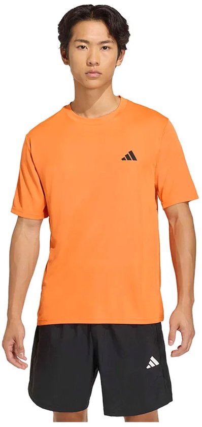 Man met oranje Adidas sport T-shirt en zwarte sportbroek, met zwart Adidas logo op de borst.