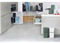 Une cuisine avec différentes poubelles Brabantia en gris foncé, bleu, vert et blanc.