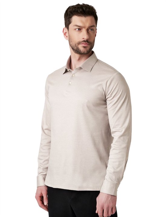 Man draagt beige longsleeve poloshirt en kijkt naar de zijkant.