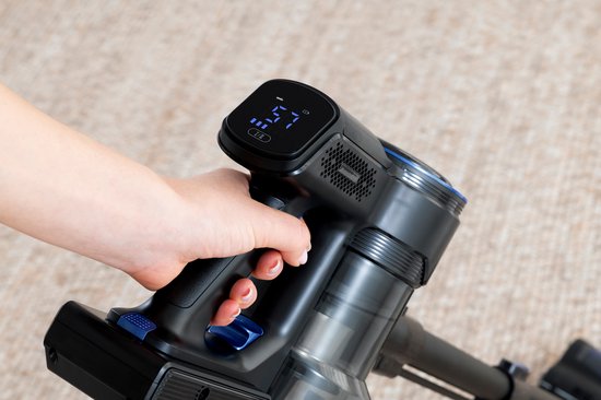 Hand vasthoudend de zwarte steelstofzuiger met een digitaal display met blauwe verlichting.