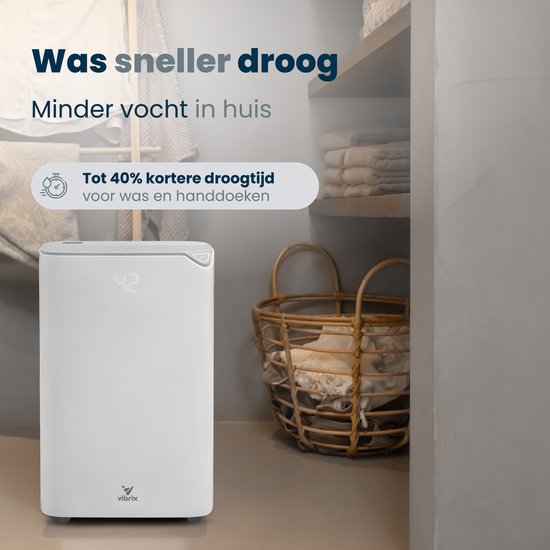 Witte Vibrix luchtontvochtiger met display '42' in een wasruimte met manden en handdoeken. Text: 'Was sneller droog. Minder vocht in huis.'